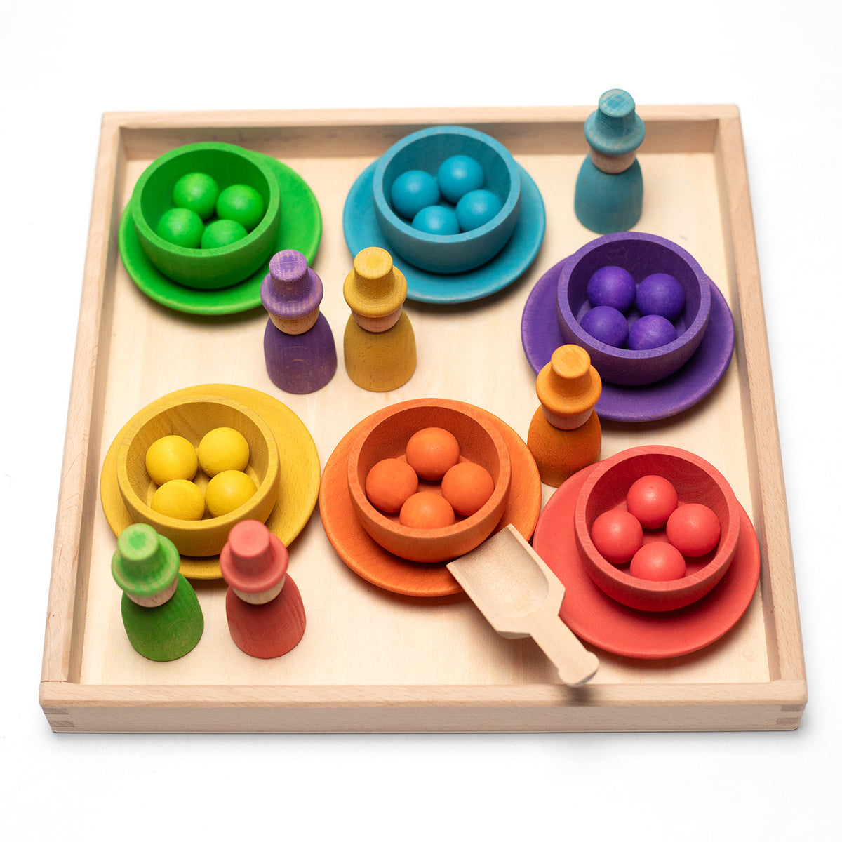 Holzspielzeug - Bunte Puppen, Schüsseln und Bälle auf einem Tablett